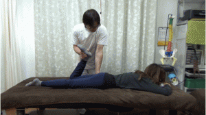 股関節を押さえて足首を持って回旋し調整