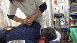両手を使って肩甲骨裏に指を押し込む
